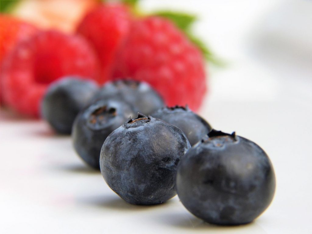 blueberries and raspberries sitting on the counter